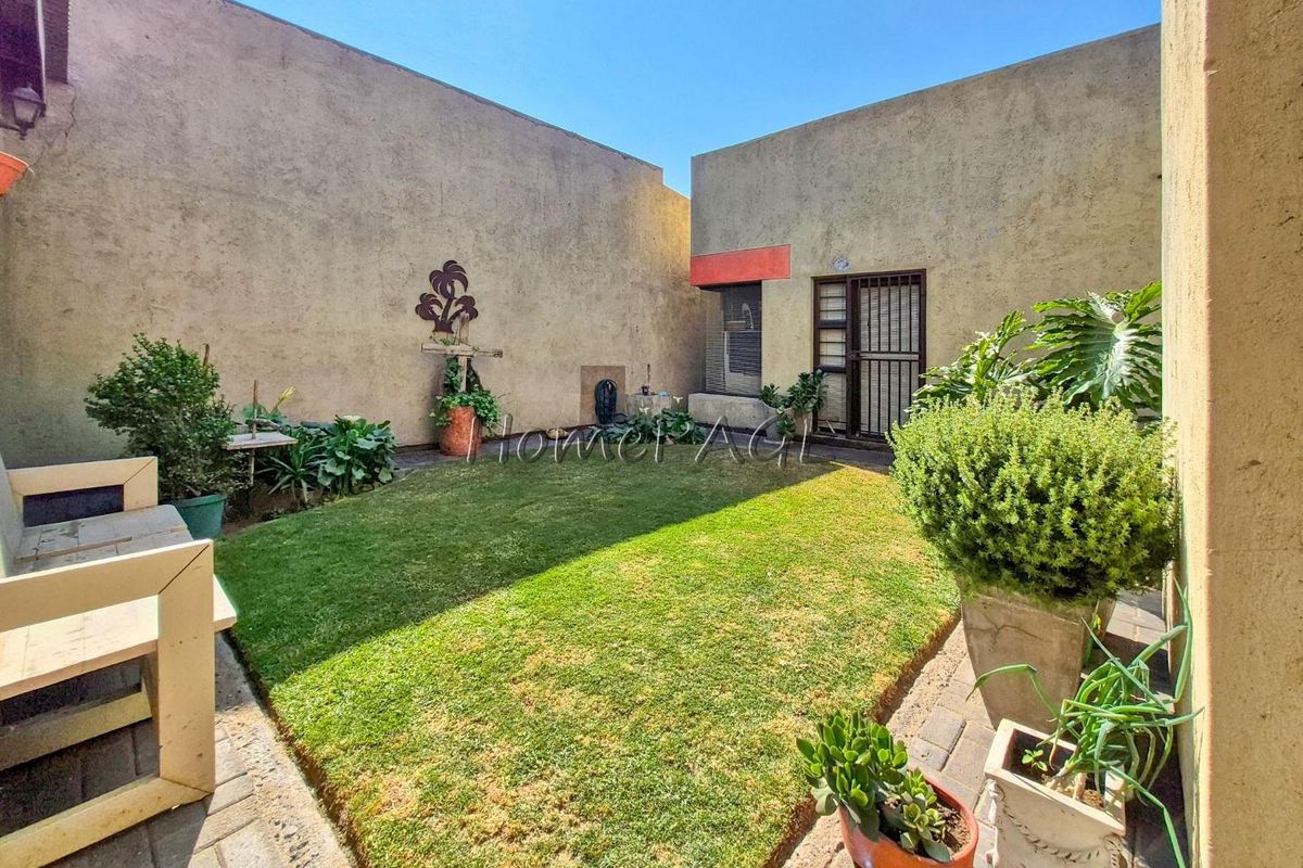 A private rear courtyard featuring a small lawn area, paved surrounds, and secure access to the main dwelling.