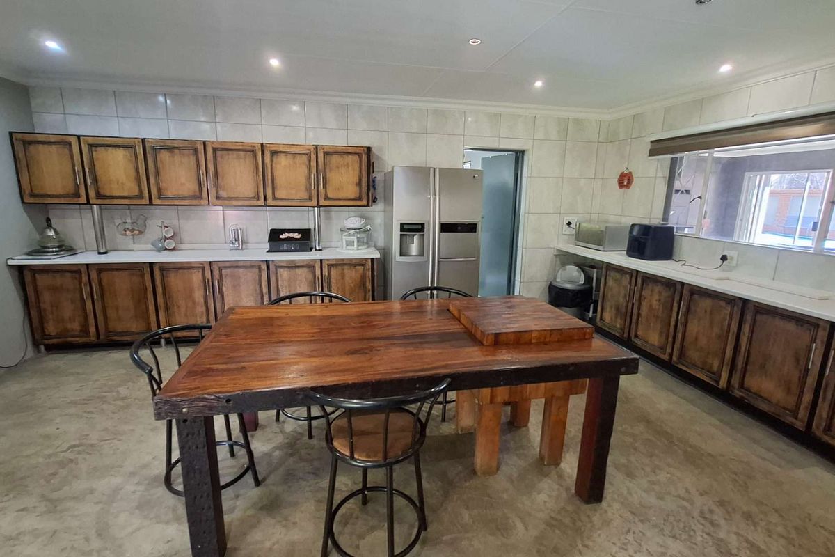 Spacious kitchen featuring extensive built-in wooden cabinetry, tiled backsplash, and recessed lighting, offering a functional layout with ample counter space.
