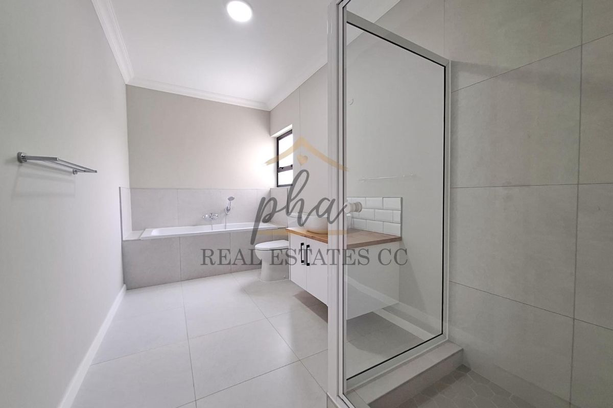 Modern bathroom featuring a built-in bathtub, separate glass-enclosed shower, and a vanity cabinet with a vessel sink.