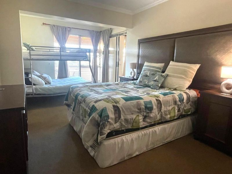 Spacious bedroom featuring carpeted flooring, cove molding, and a sliding glass door providing access to an outdoor area.