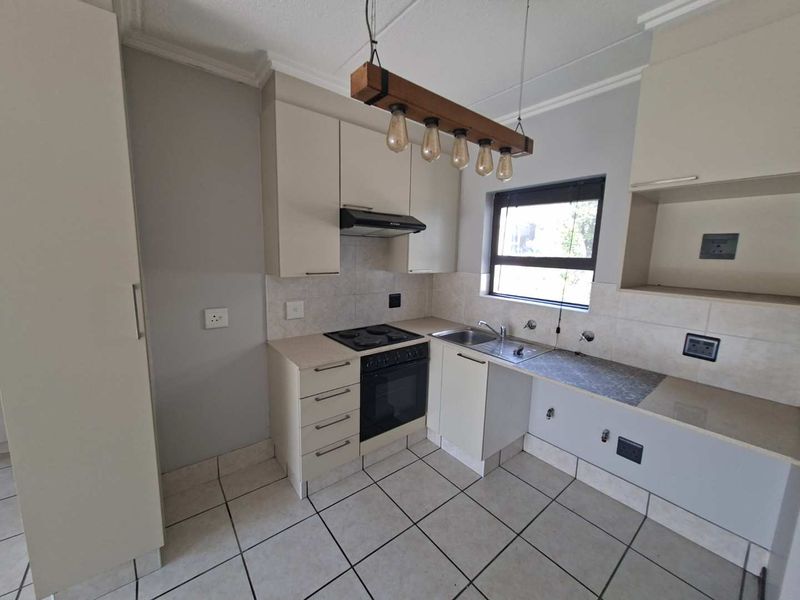 Functional kitchen featuring built-in cabinetry, electric stove with extractor, tiled backsplash, and tiled flooring. Requires minor repairs to cabinetry and plumbing fixtures.