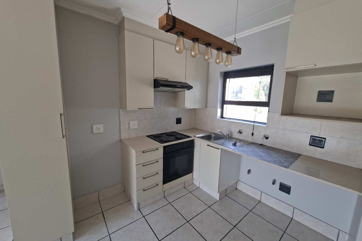 Functional kitchen featuring built-in cabinetry, electric stove with extractor, tiled backsplash, and tiled flooring. Requires minor repairs to cabinetry and plumbing fixtures.