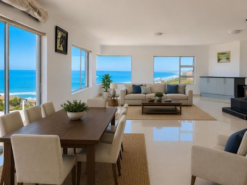 Spacious open-plan living and dining area featuring large windows, tiled floors, a modern fireplace, and panoramic ocean views.