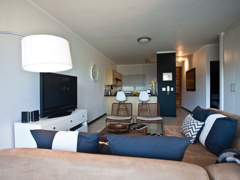 Open plan living area featuring tiled flooring and a functional kitchen with built-in cabinetry and countertop space.