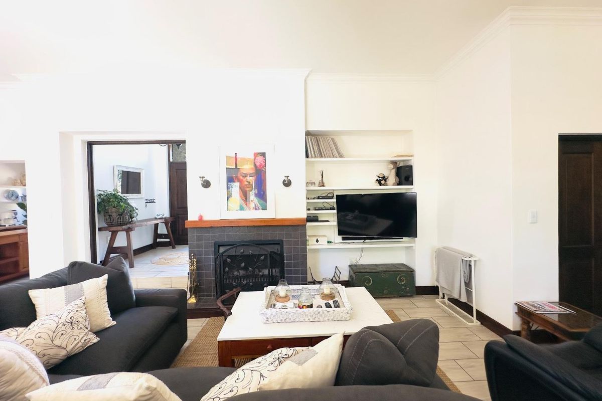 A comfortable living room featuring a tiled fireplace, built-in shelving, and tiled flooring, providing a warm and inviting space for relaxation.