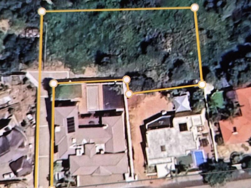 An aerial view of a residential plot showing property boundaries and surrounding neighborhood context.