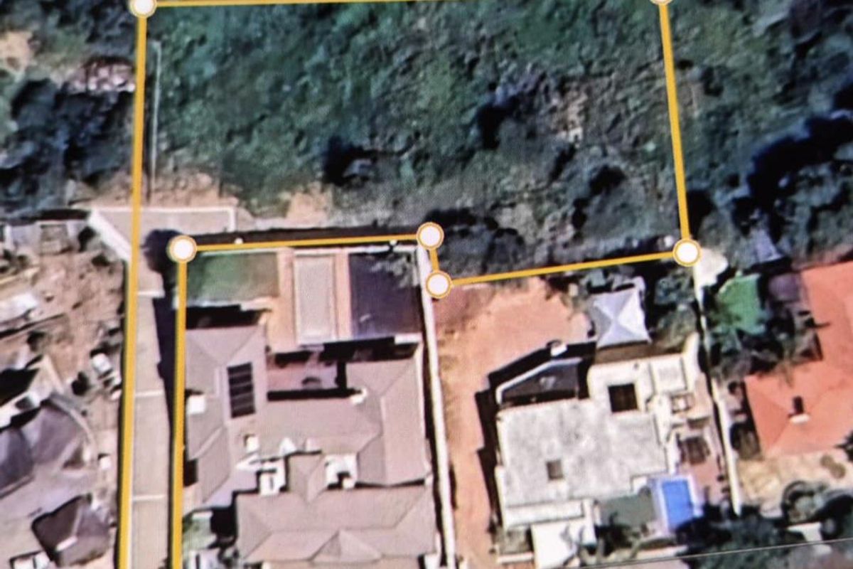 An aerial view of a residential plot showing property boundaries and surrounding neighborhood context.