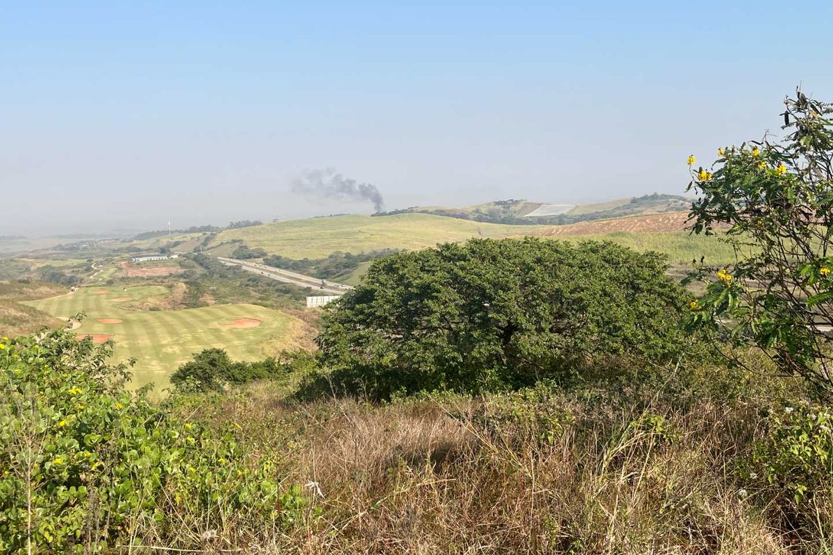 A scenic elevated view overlooking a golf course and surrounding rolling hills, showcasing the natural landscape and terrain of the vacant residential property.