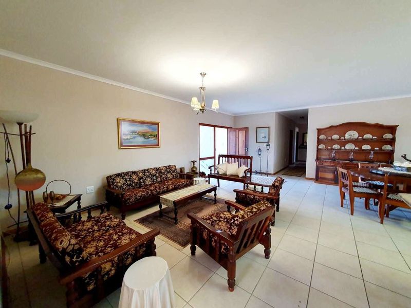 Spacious open-plan living and dining area featuring neutral wall tones and tiled flooring, providing a versatile layout for family living.