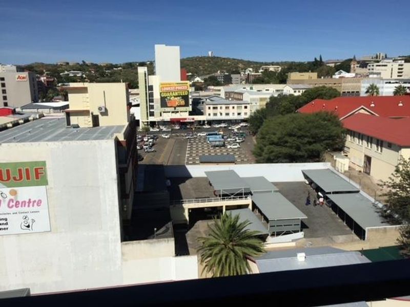 Elevated urban view overlooking surrounding commercial buildings, parking facilities, and city infrastructure.