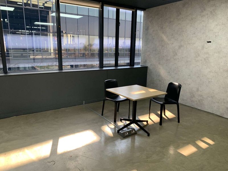 Modern office space featuring polished concrete floors, large windows providing ample natural light, and integrated floor power outlets.