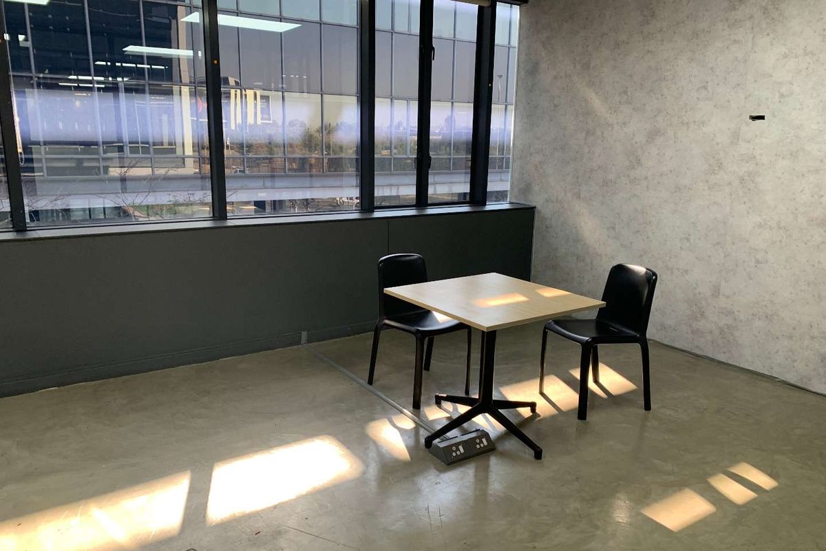 Modern office space featuring polished concrete floors, large windows providing ample natural light, and integrated floor power outlets.