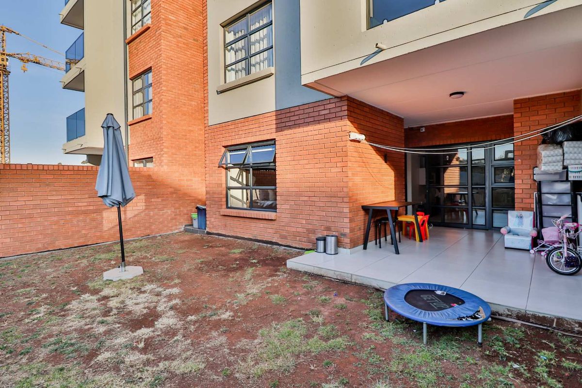 Ground floor apartment featuring a tiled patio area and a private garden space with brick exterior walls.