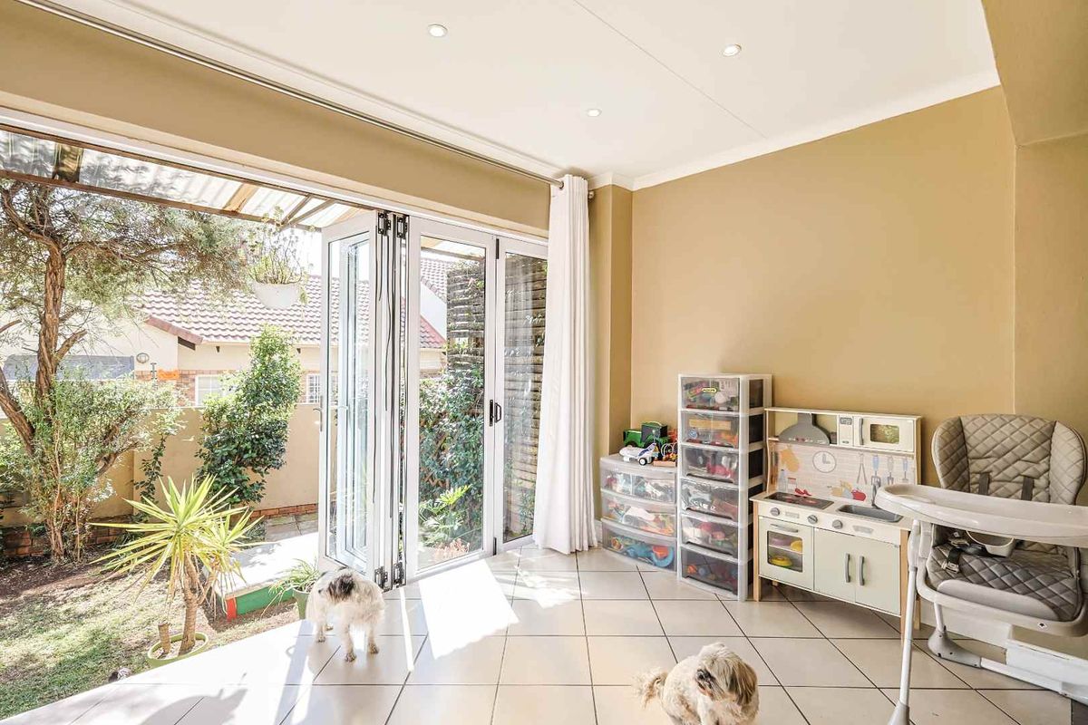 Bright living area featuring tiled flooring and large aluminium folding doors that provide seamless access to the garden.