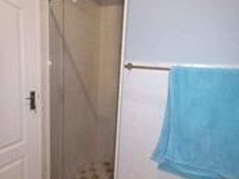 A functional bathroom featuring a shower enclosure with tiled walls and flooring, providing a clean and practical space.