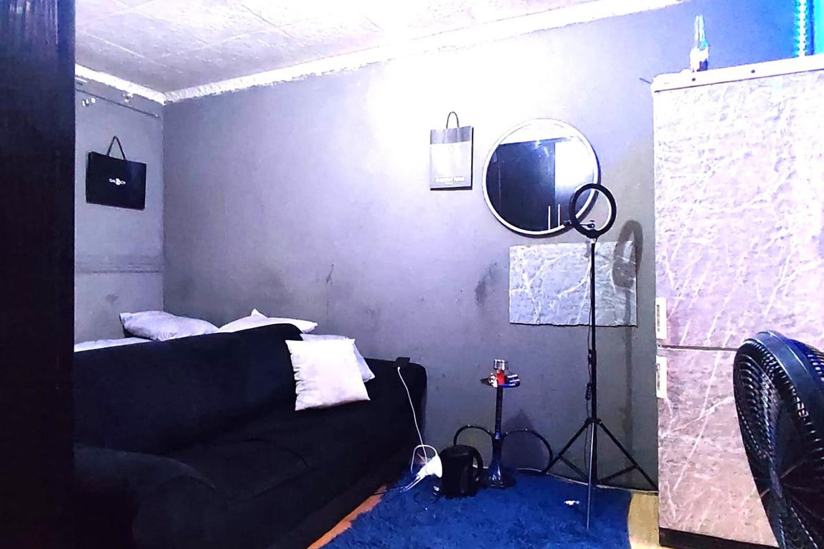 A small living area featuring dark grey walls and a textured ceiling, providing a compact space for relaxation.