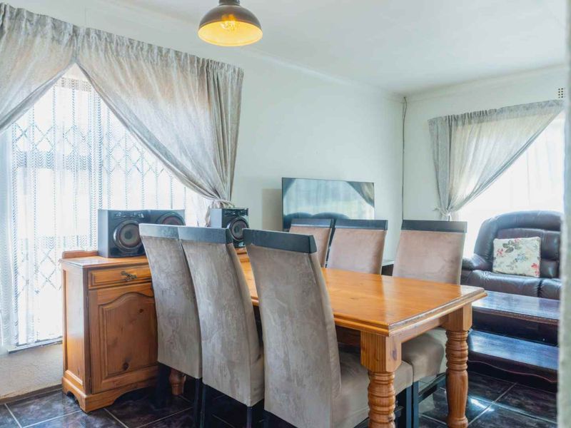 A functional dining area featuring tiled flooring and natural light, providing a comfortable space for family meals and gatherings.