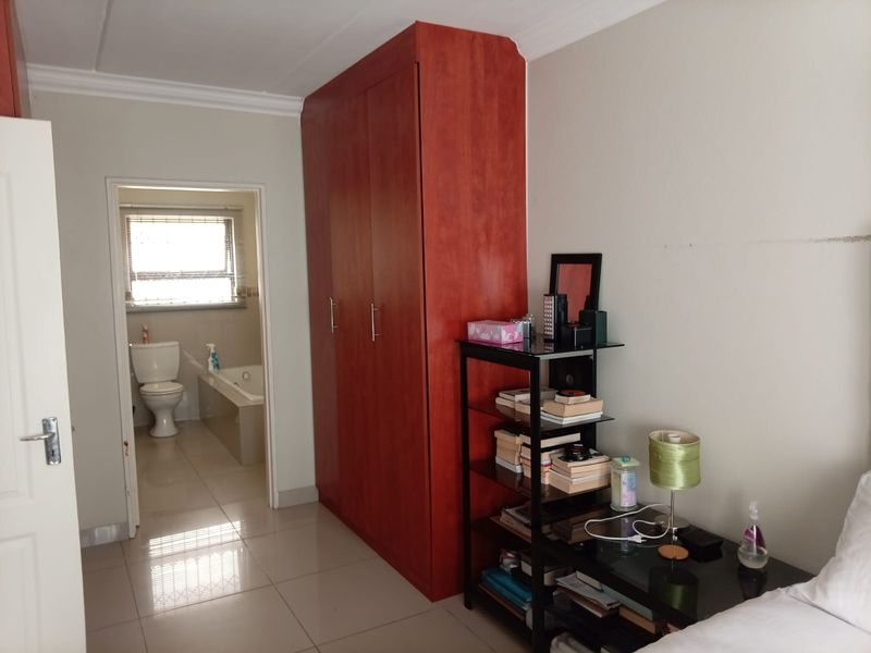 Bedroom featuring tiled flooring, a large built-in wardrobe, and direct access to an en-suite bathroom.