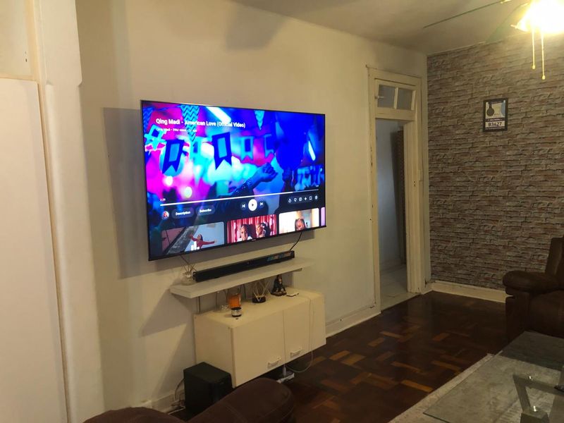 Living room featuring parquet flooring and a brick-effect feature wall, providing a distinct character to the space.