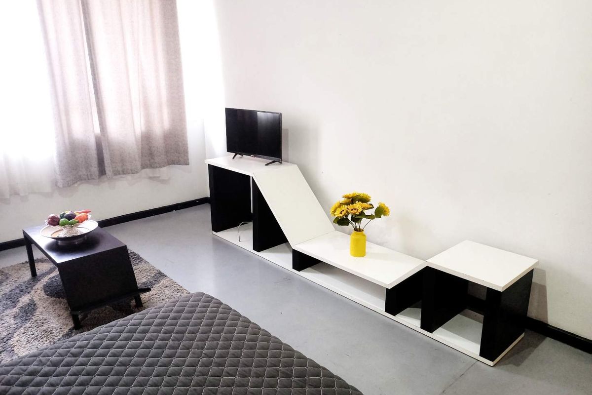 A living room area featuring a modern, multi-level built-in media console and neutral flooring.