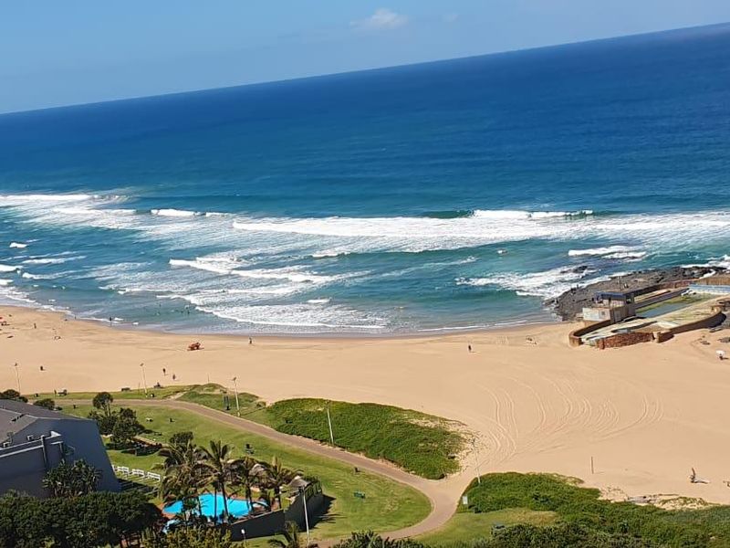 Elevated panoramic view overlooking the coastline, sandy beach, and ocean.