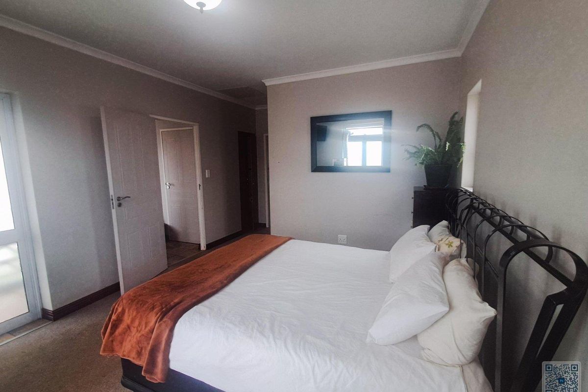 A bedroom featuring neutral wall tones, carpeted flooring, and a glass door providing access to the exterior.