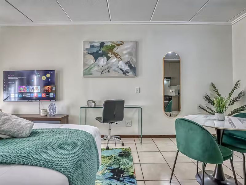 A bedroom featuring tiled flooring and a drop ceiling, offering a functional living space with neutral wall finishes.