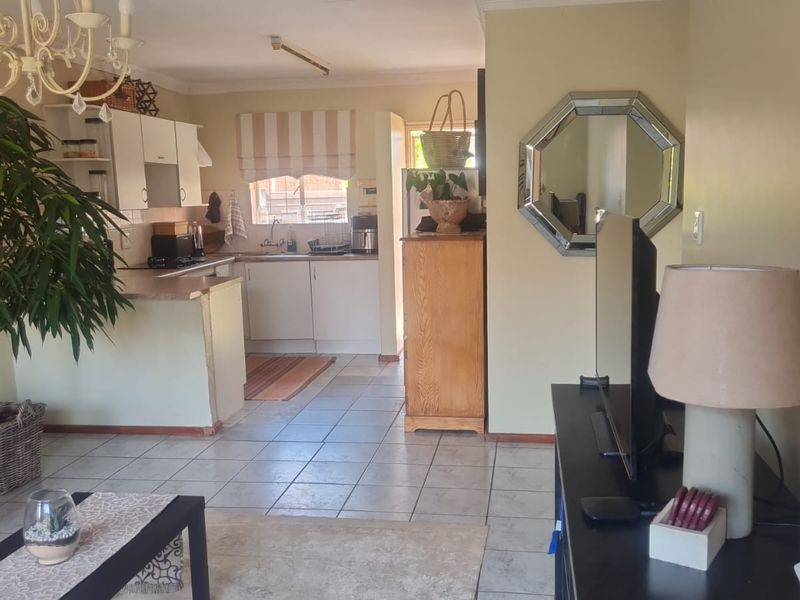 Open plan living and kitchen area featuring tiled flooring and functional cabinetry, offering a versatile space for daily living and dining.