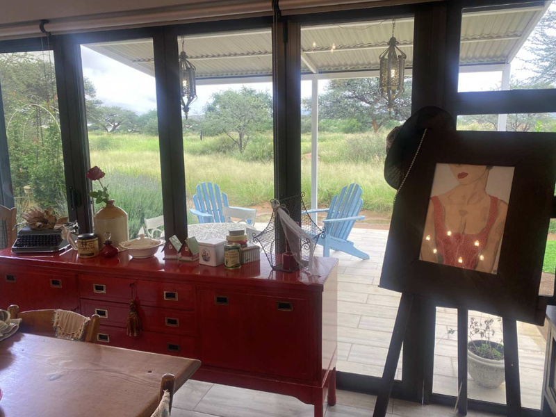 An open-plan living space featuring large glass sliding doors that provide seamless access to a covered patio and garden views.