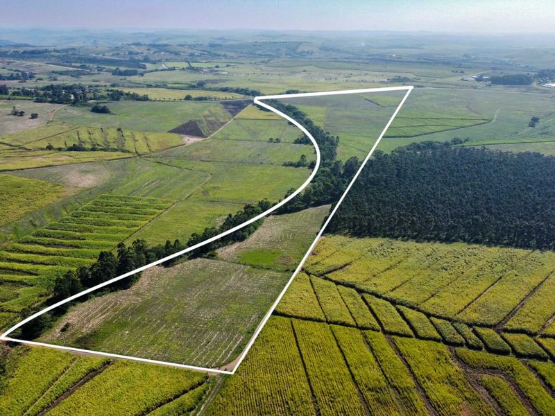 An aerial view of a large agricultural farm property with clearly demarcated boundaries, showcasing expansive fields and surrounding rural landscape.