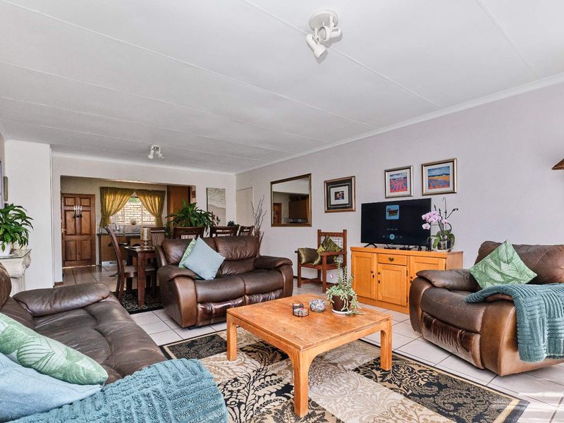 Spacious open-plan living and dining area featuring neutral tiled flooring and coved ceilings, providing a functional layout for family living.