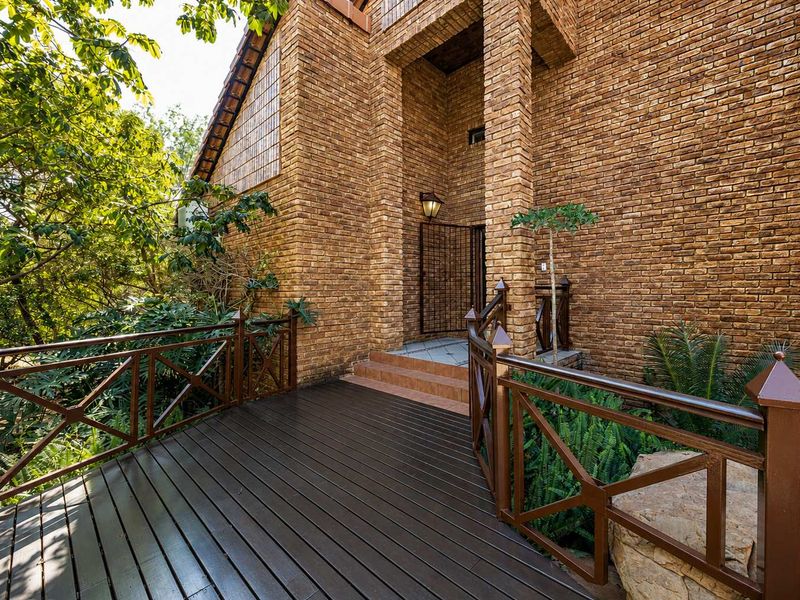A welcoming front entrance featuring a raised timber deck, brick facade, and tiled steps leading to the main doorway.