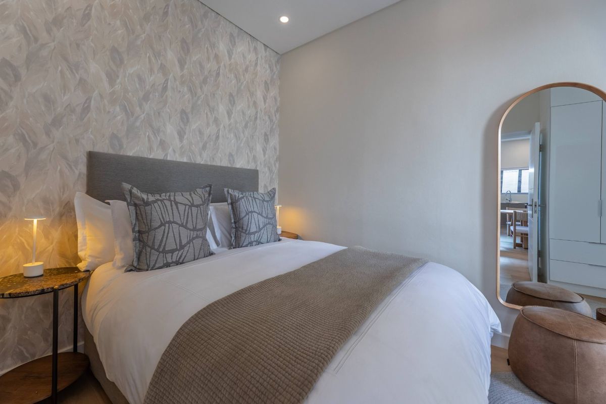 A well-appointed bedroom featuring modern recessed lighting and a stylish feature wall, offering a clean and contemporary living space.