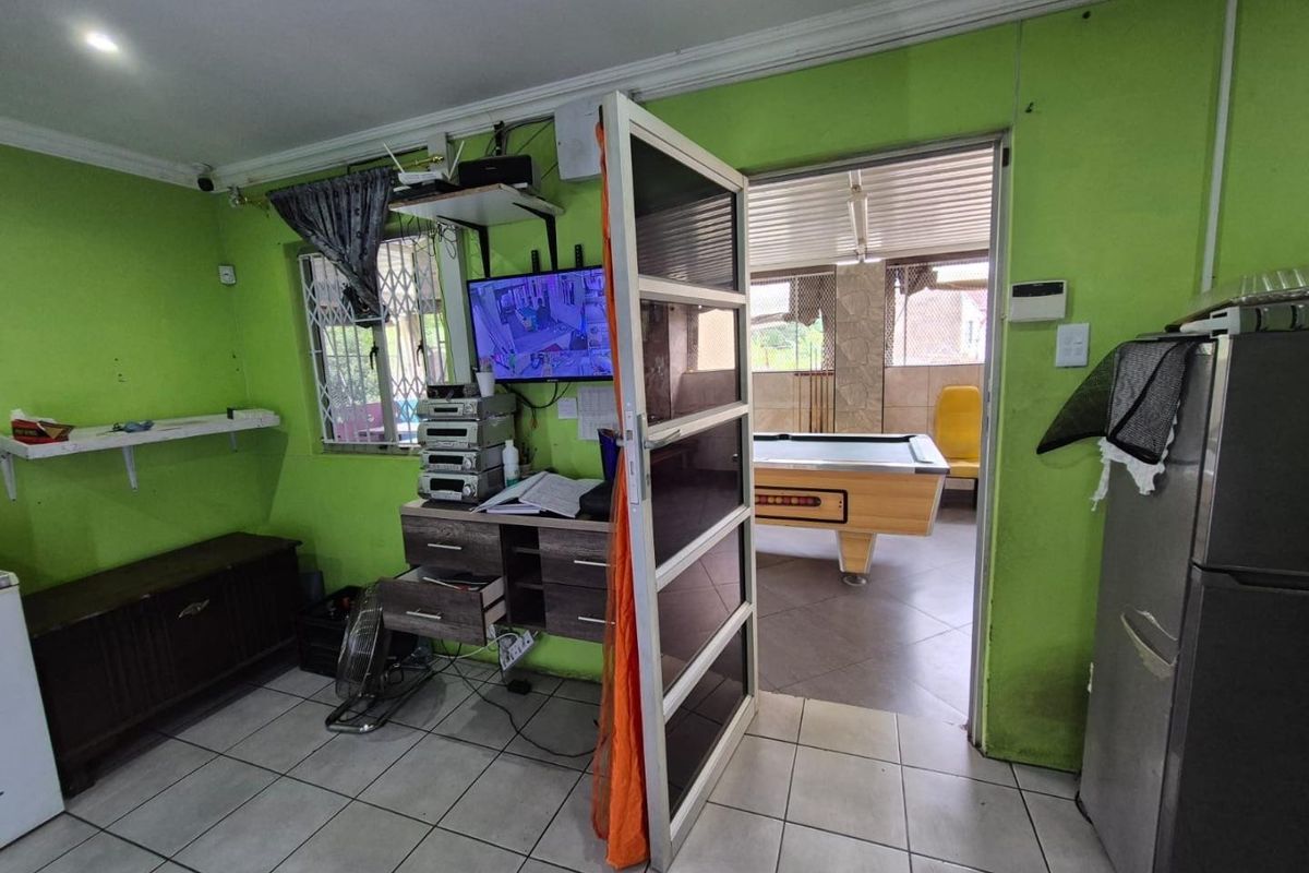 Living area featuring tiled flooring and security gate access to an adjoining patio space.
