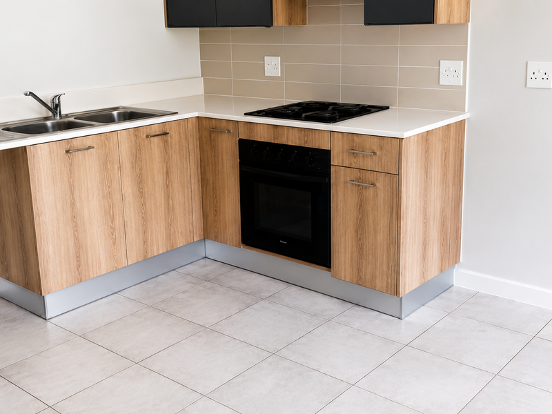 Modern kitchen featuring light wood-grain cabinetry, quartz countertops, a built-in oven, gas hob, and neutral ceramic floor tiles in a clean, contemporary layout.