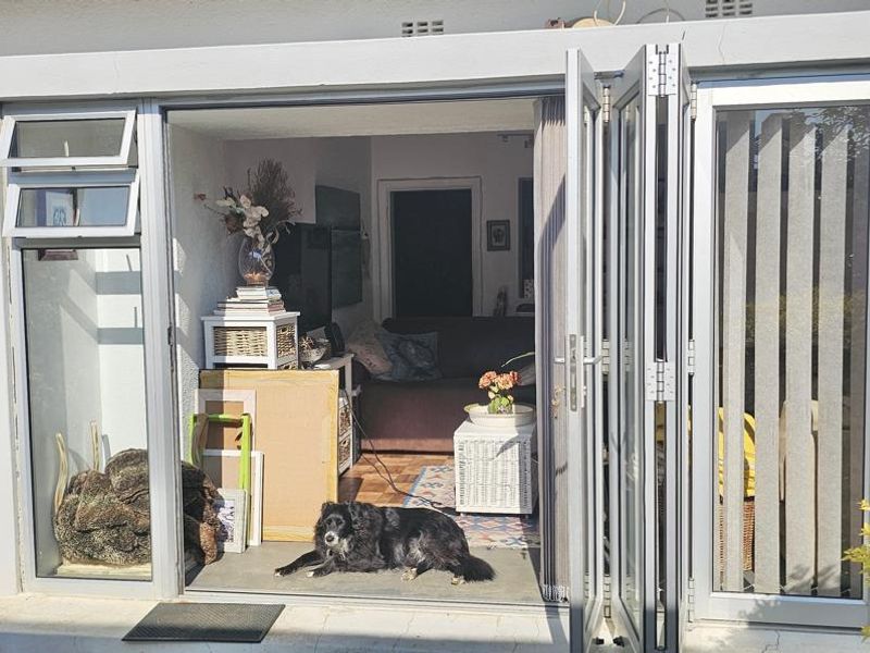 A covered patio area featuring aluminium folding doors that open into the living space, providing a seamless transition between indoor and outdoor living.