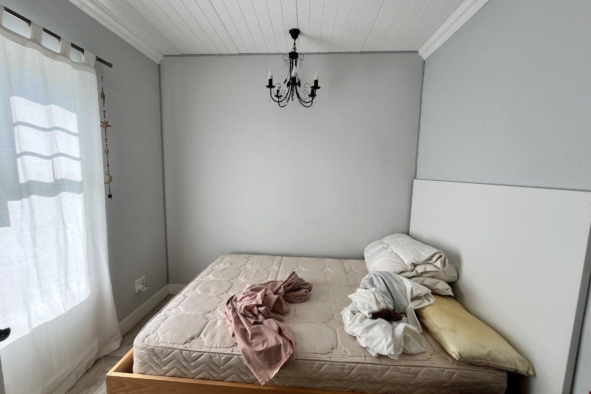 A bedroom featuring a tongue and groove ceiling with crown molding and a central chandelier fixture.