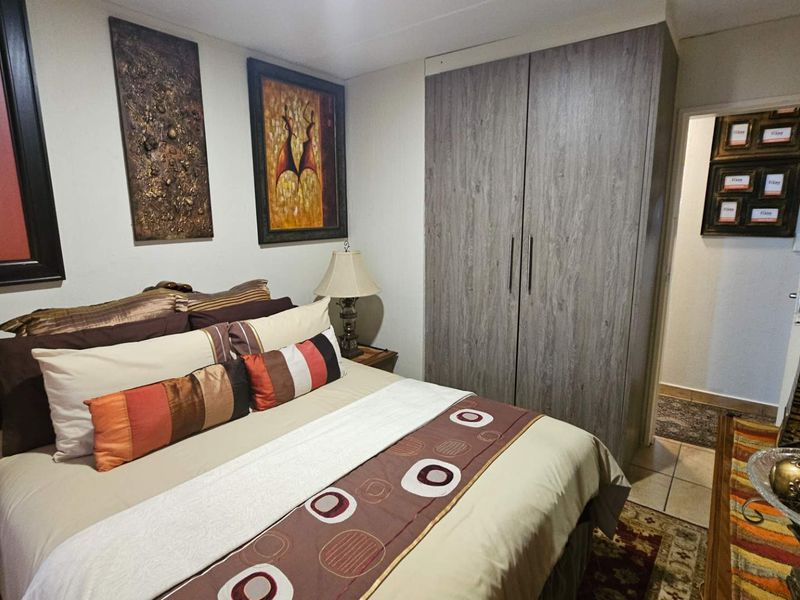 A well-maintained bedroom featuring a built-in wardrobe and tiled flooring, providing a functional and comfortable living space.