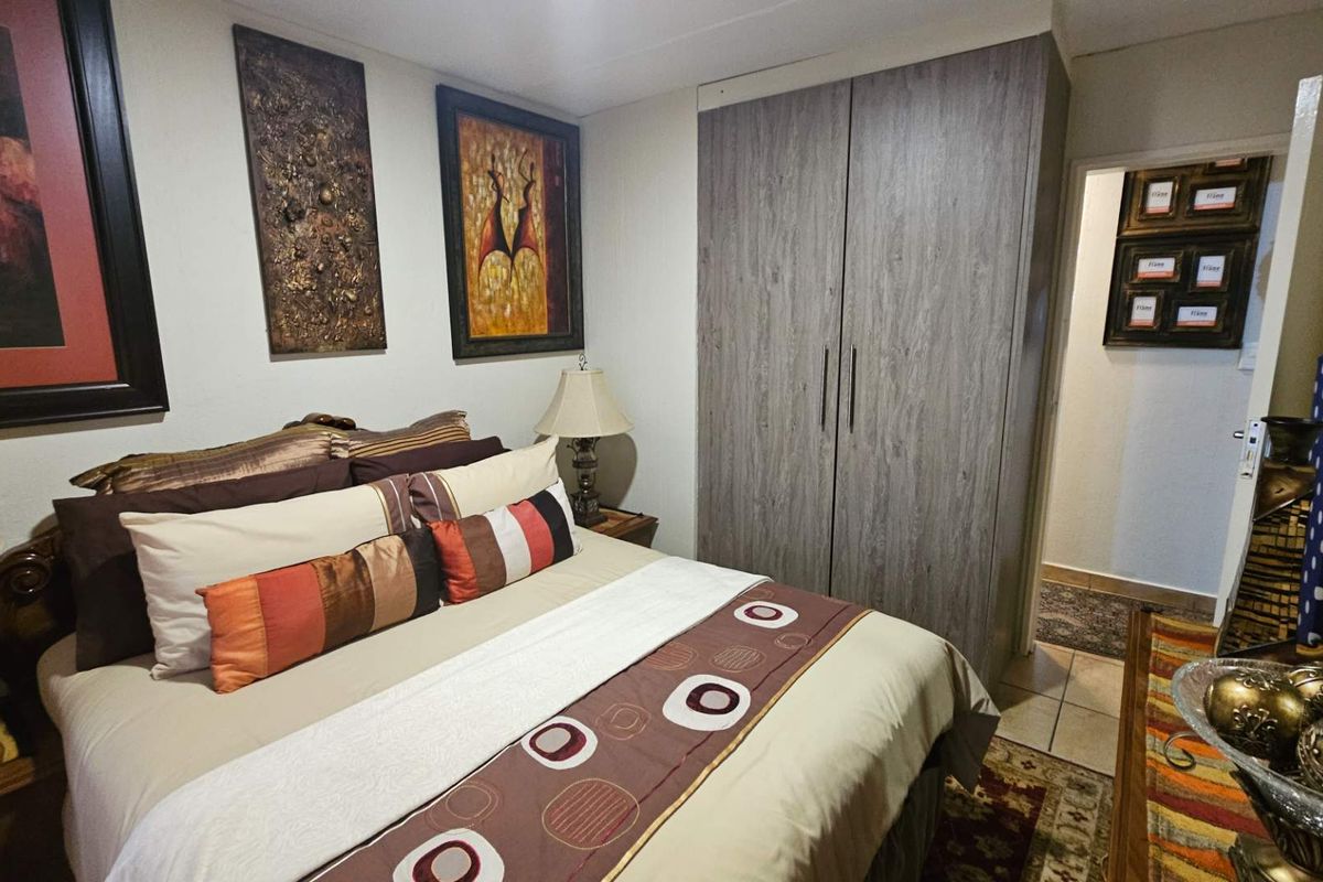 A well-maintained bedroom featuring a built-in wardrobe and tiled flooring, providing a functional and comfortable living space.