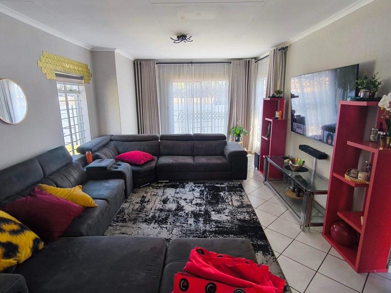 A comfortable living room featuring tiled flooring and a large sliding glass door that provides access to the outdoor area.