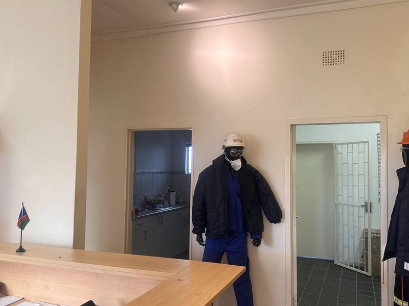 Office reception area featuring a built-in desk and access to adjacent utility spaces through standard doorways.