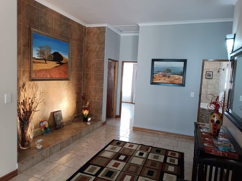 A well-maintained living area featuring tiled flooring, a prominent tiled feature wall with a built-in hearth, and neutral wall finishes.
