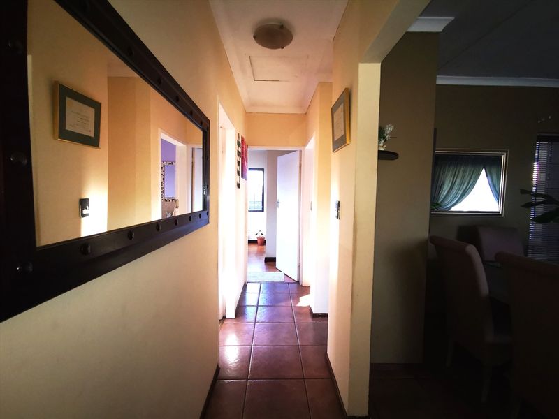 A functional hallway featuring tiled flooring and neutral wall finishes, providing access to multiple rooms within the home.