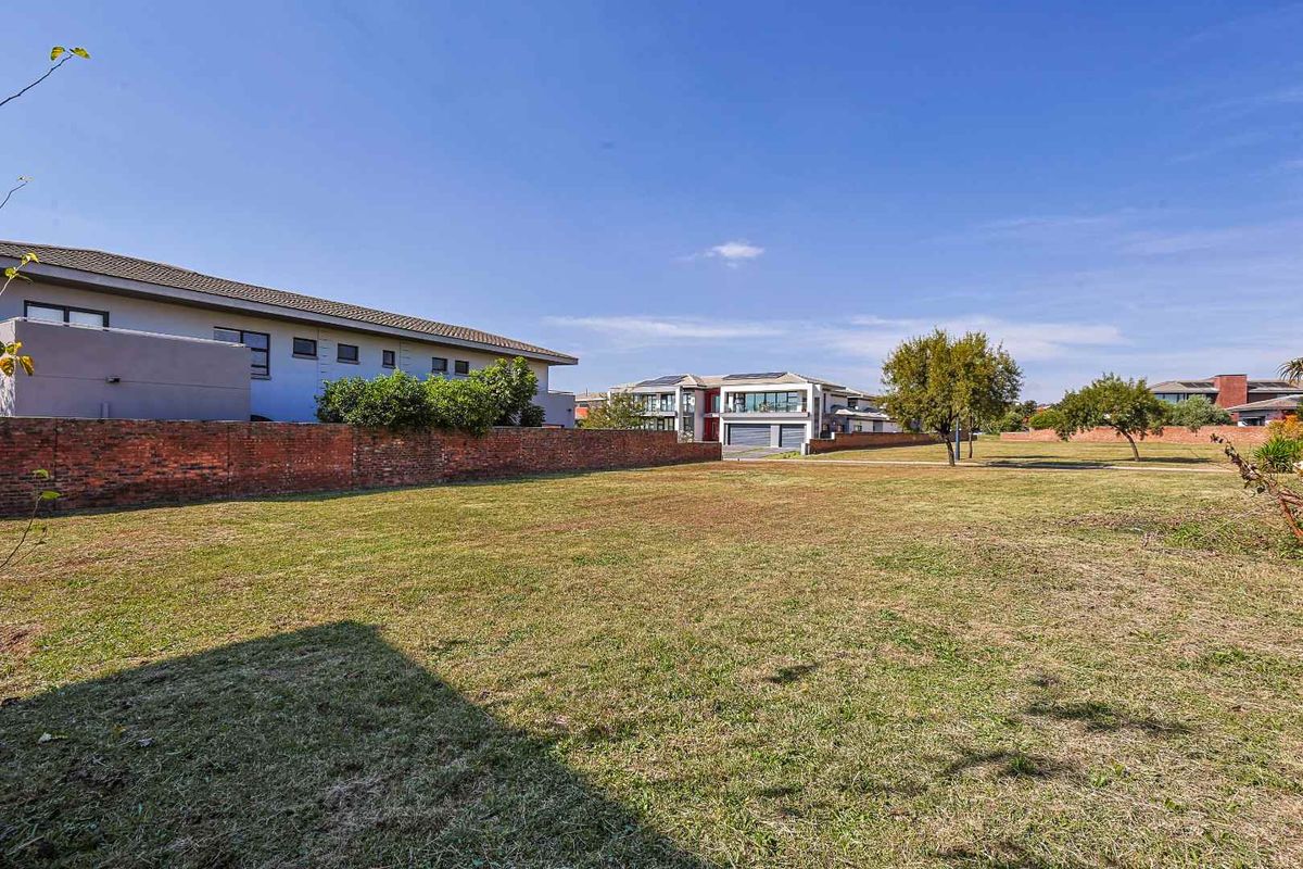 A spacious, level vacant residential plot featuring established boundary walls and surrounding neighborhood views, ideal for new construction.