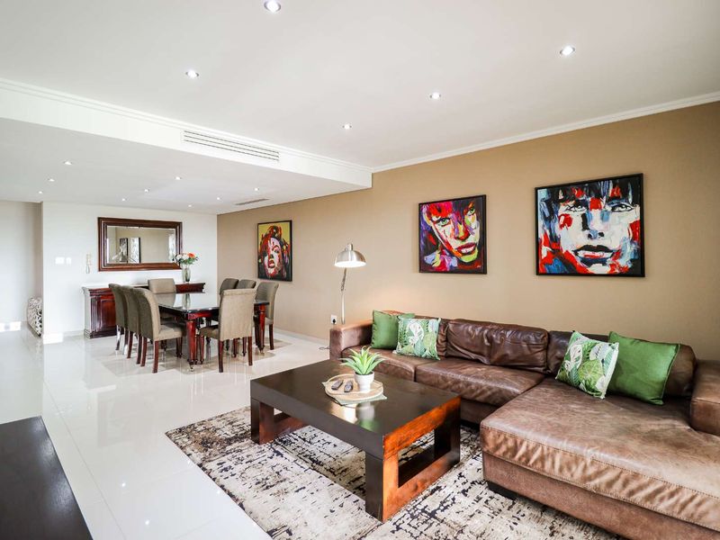 Spacious open-plan living and dining area featuring polished porcelain floor tiles, recessed downlighting, and integrated ducted air conditioning.