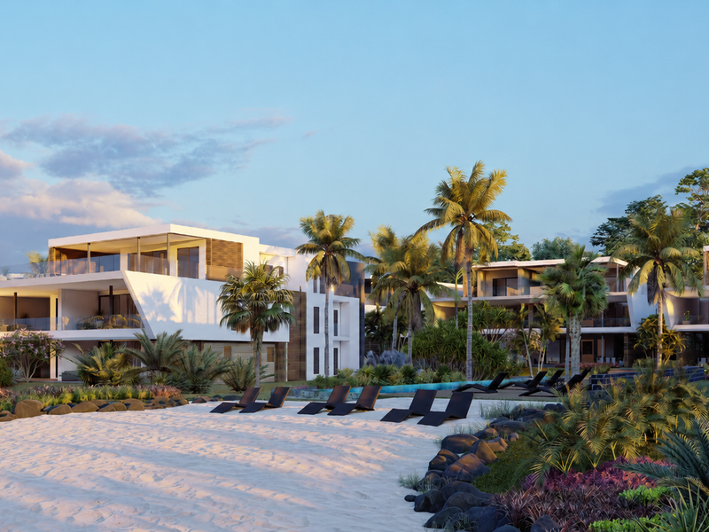 A high-end modern apartment complex featuring contemporary architecture, glass balconies, and beautifully landscaped grounds leading to a private sandy beach area.