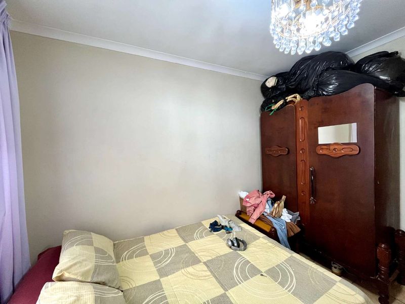 A bedroom featuring a crystal chandelier and coving, providing a functional space for rest.