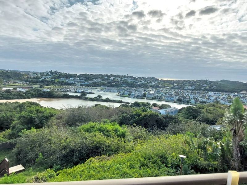 Elevated panoramic view overlooking the coastal landscape, estuary, and surrounding residential estate.