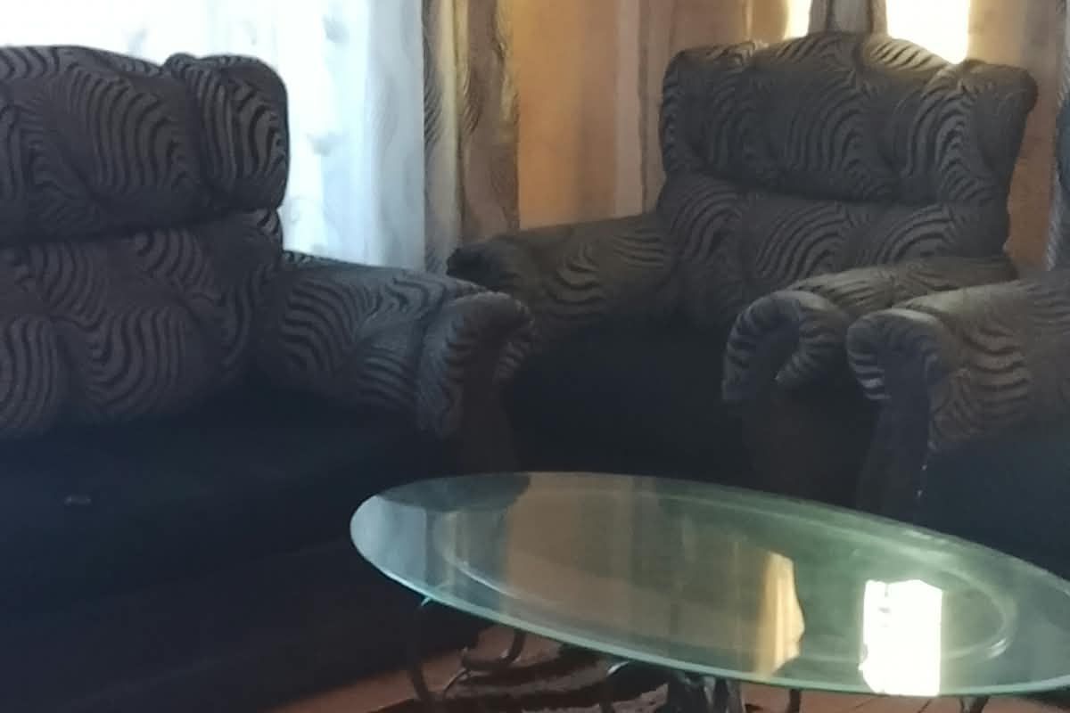 A living room area featuring tiled flooring and window treatments.