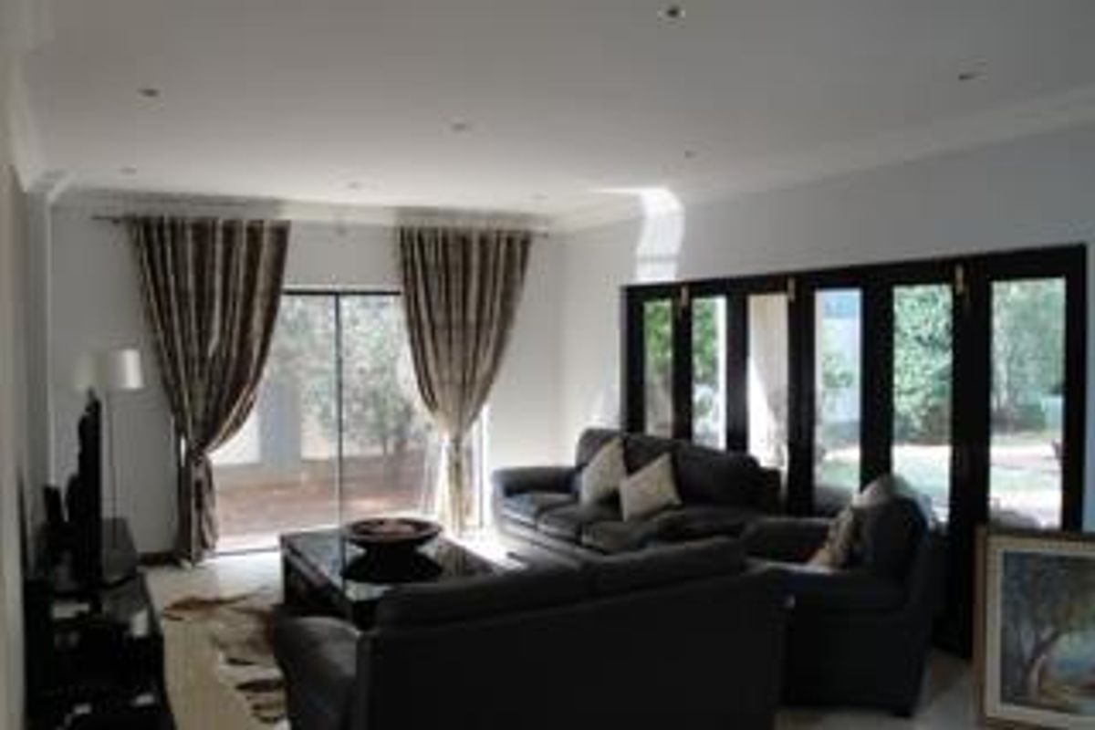 Spacious living room featuring large black-framed sliding doors that provide ample natural light and direct access to the outdoor area.